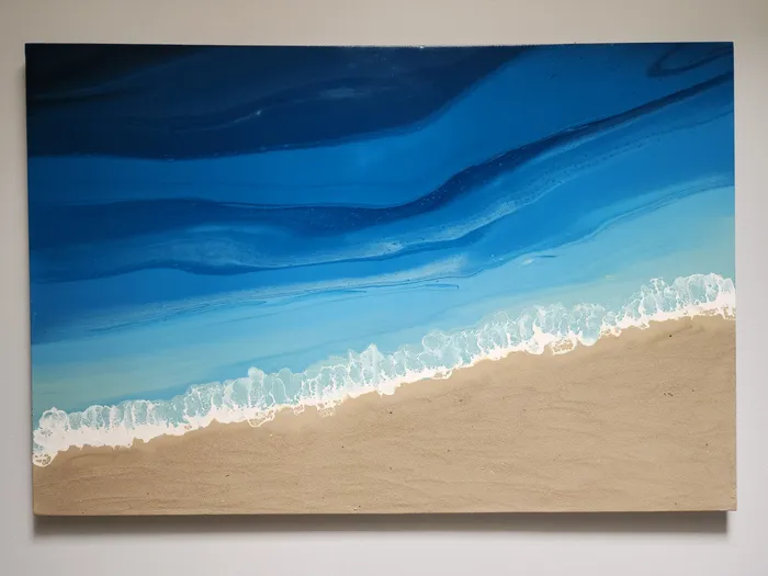 Large, rectangular canvas with fluid art seascape. Foaming white ocean meets real sand on the canvas.