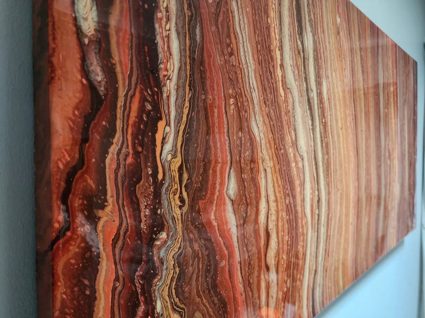 An angled view of the canvas showing its size and distinct red, orange, and tan ribbon patterns.
