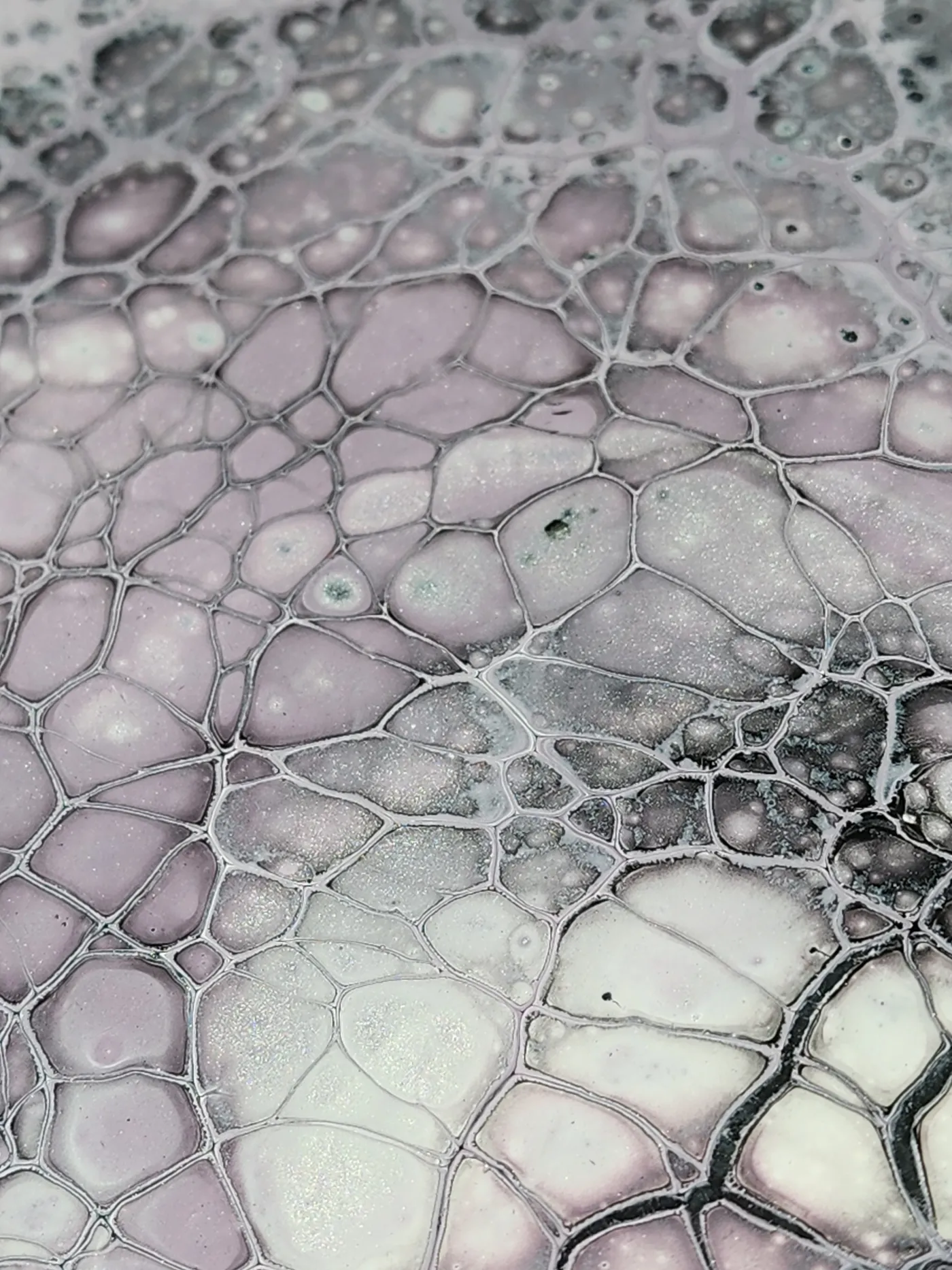 An up-close shot of a small, square fluid art piece showing off details of lavender and gray fluid cells with their metallic pigment.