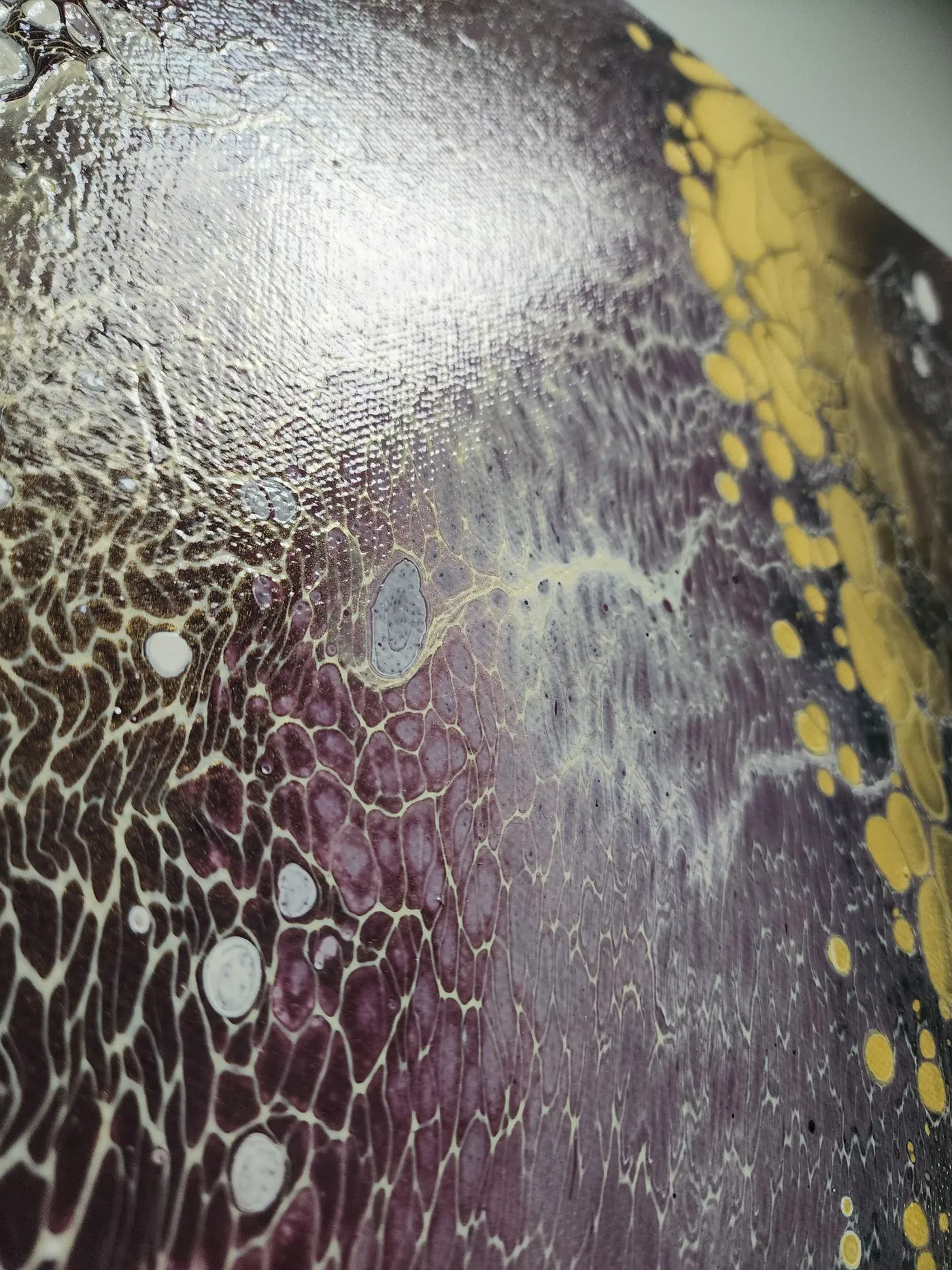 An up-close shot of the canvas showing the detail of the fluid art cells in violet, gold, and white.
