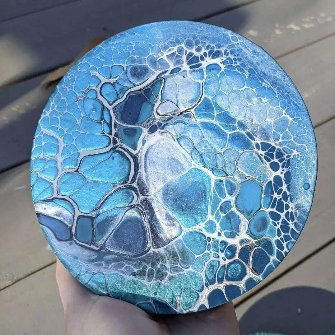 The same round pour in full daylight, bright turquoise cells webbed with white and silver.