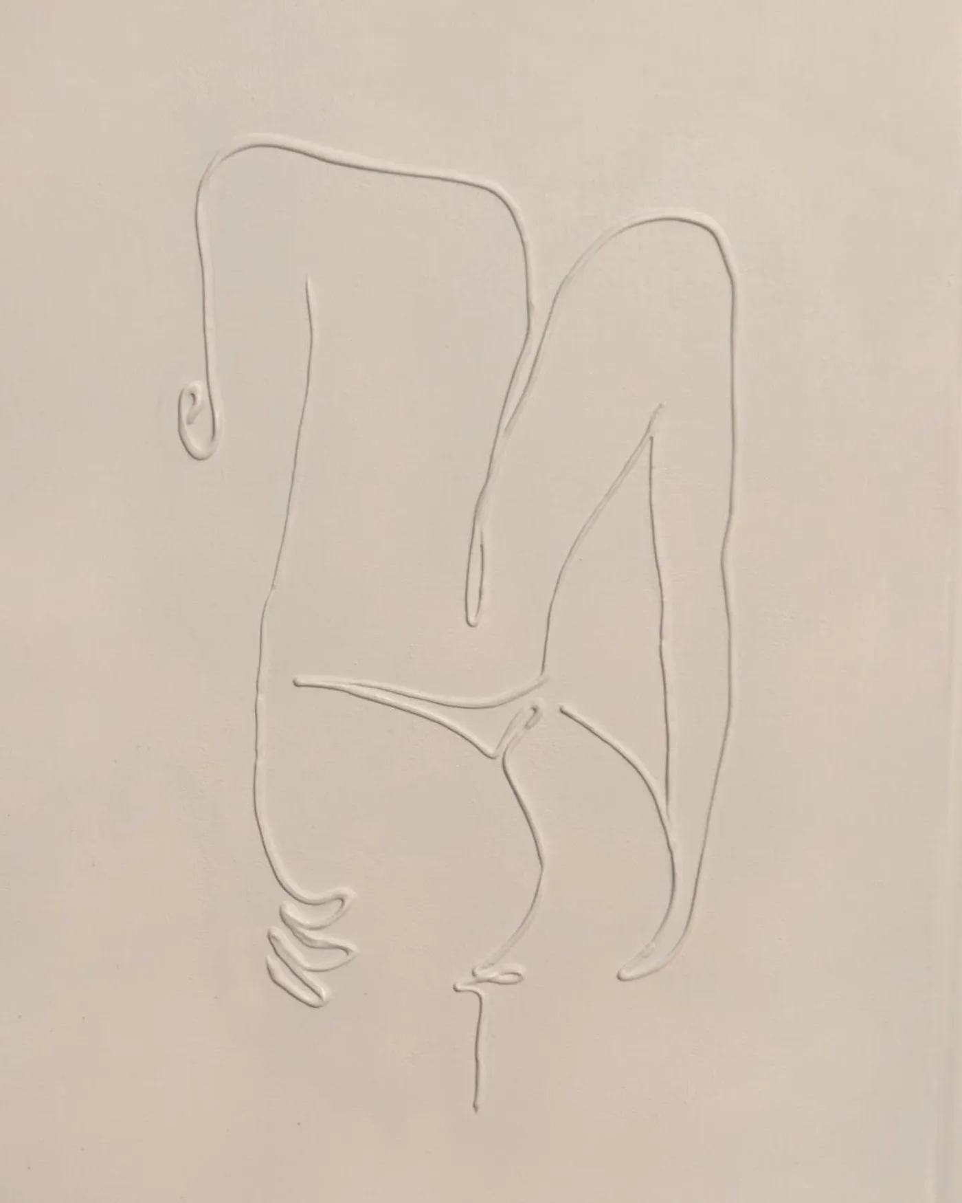 Cream canvas with a raised plaster line drawing of a seated figure, drawn as a single continuous contour.