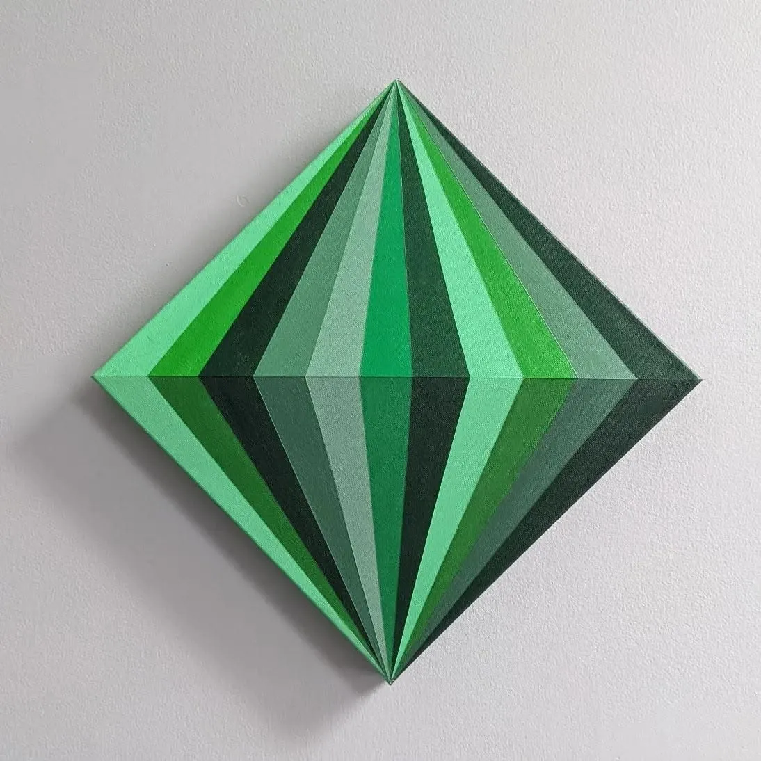 Square canvas hung as a diamond, painted with faceted green triangles that read as a cut gemstone.