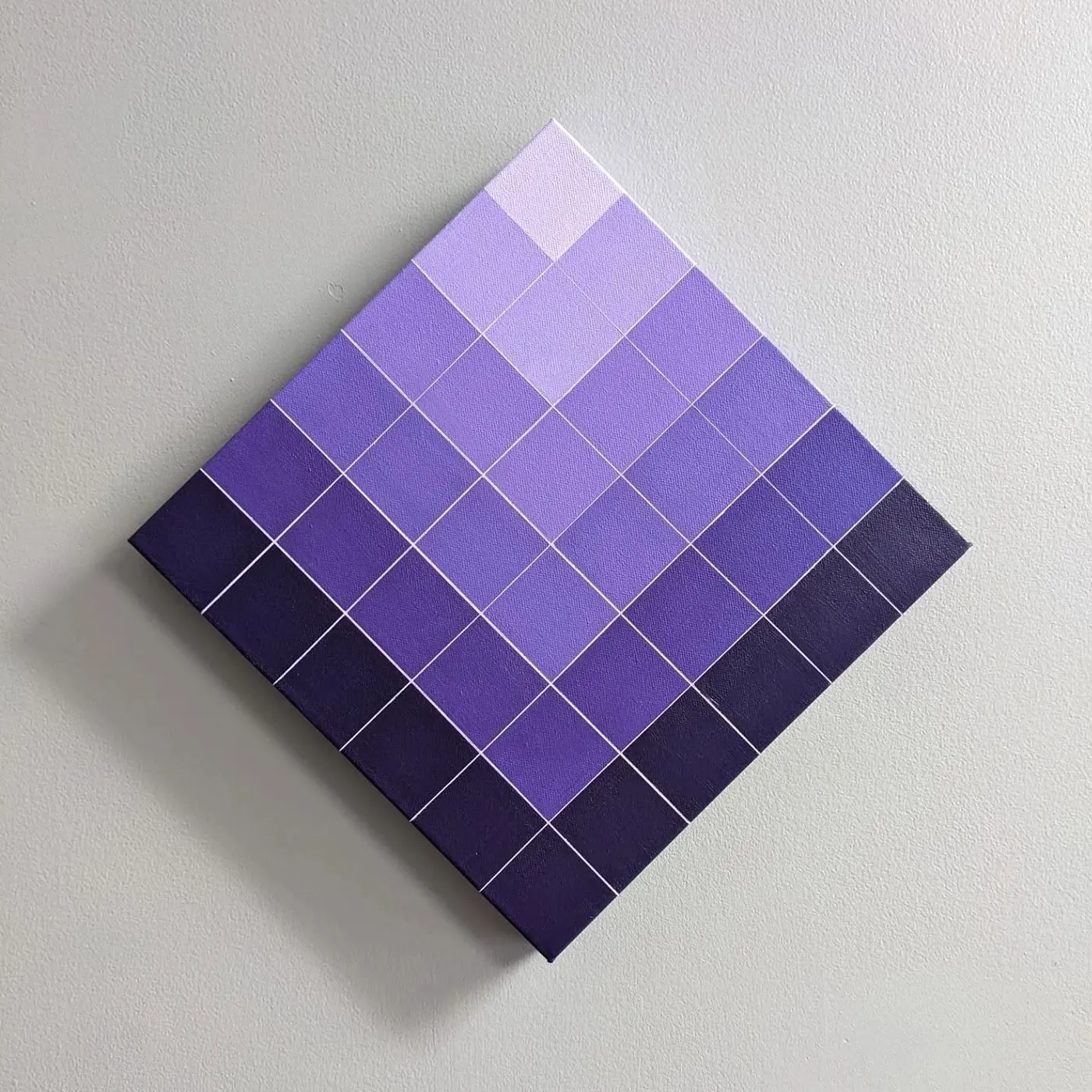 Square canvas hung as a diamond, filled with a grid of purple squares graduating from deep violet at the edges to pale lilac at the top.